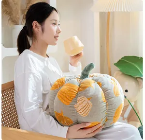 Mannequin asiatique tenant un coussin en gaze en forme de citrouille dans une chambre