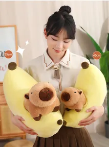 Primer plano de una modelo sosteniendo un peluche de capibara con forma de plátano.