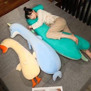 Vista detallada de una mujer asiática durmiendo con almohadas largas de peluche de animales en cama gris