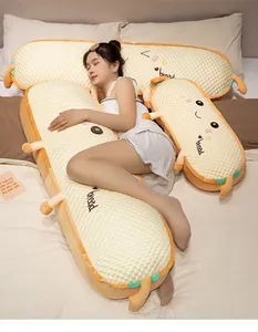 Langes, niedliches Plüschkissen in Brotform, präsentiert mit schlafendem Model im Bett