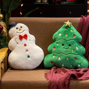 Détail en gros plan des coussins festifs en peluche bonhomme de neige et sapin de Noël