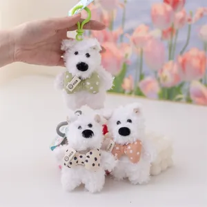 Dettaglio di tre portachiavi a forma di cucciolo di Westie in peluche bianco con papillon.