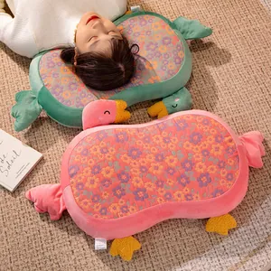 Primer plano de almohada cervical con forma de ganso, estampado floral y detalles