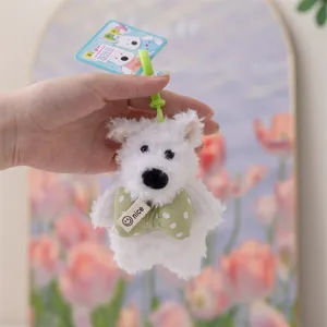 Primo piano di portachiavi in peluche Westie bianco con papillon verde a pois