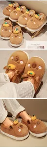 Close-up of cute plush capybara slippers with orange accessory and soft warm lining.