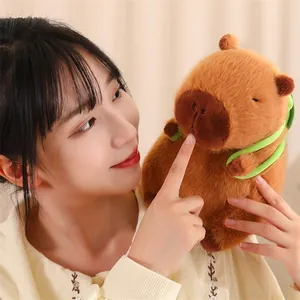 Gros plan d'une peluche capybara marron douce tenue par une personne dans un décor