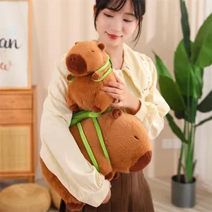 Vue détaillée d'une peluche de capybara marron tenue par une femme dans une pièce.
