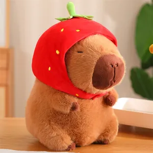 Vue détaillée d'une peluche de capybara douce avec un chapeau de fraise rouge mignon