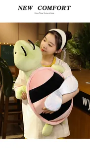 Ragazza asiatica con un grande cuscino di peluche tartaruga-ape in un accogliente ambiente domestico