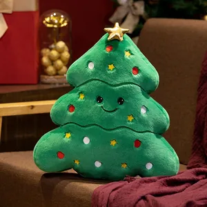 Gros plan d'un coussin en peluche sapin de Noël avec visage souriant et étoiles décoratives