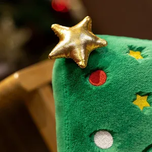 Gros plan d'une étoile dorée et de la texture peluche d'un coussin sapin de Noël vert