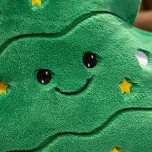 Détail macro du tissu en peluche et du joli visage brodé sur l'oreiller sapin de Noël vert