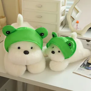 Detailed close-up of white Westie plushies with green frog hats on a clean white desk.