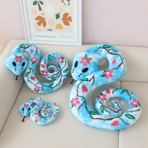 Three sizes of blue floral plush snake toys with cherry blossom prints displayed on a sofa