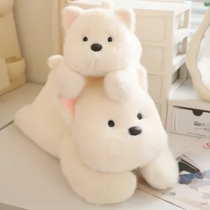 Close-up of cute white Westie dog plush toys stacked on a desk