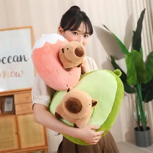 Primer plano de peluches de carpincho de fresa y aguacate sostenidos por una modelo