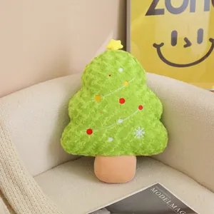 Gros plan d'un coussin en peluche vert en forme de sapin de Noël sur un canapé blanc