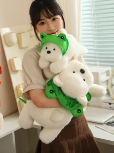 Close-up detail of soft white Westie plush dog wearing a cute green frog costume hat