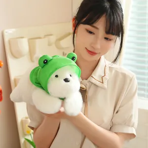 Cute soft West Highland Terrier plush toy wearing a green frog hood held by a person
