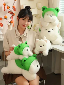 Young Asian woman posing with cute white Westie dog plush toys wearing green frog hats