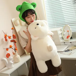 Detail shot of a large white Westie plush dog held by a model in a cozy home office setting