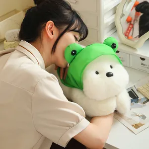 Soft Westie dog plush toy with green frog hat held by a girl for cozy comfort.
