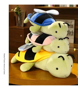 Morbidi peluche impilati a forma di ape-tartaruga in blu, rosa e giallo su un tavolo