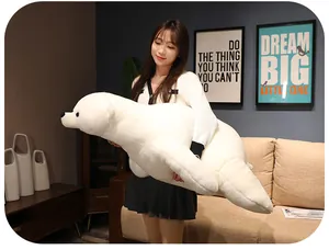Young Asian woman holding a giant soft white polar bear plush toy in a cozy room