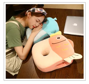 Mujer joven usando almohada de peluche de pez rosa con calentador de manos.