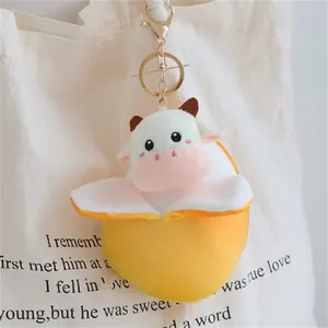 Vista dettagliata di un simpatico portachiavi a forma di mucca di peluche su una borsa.