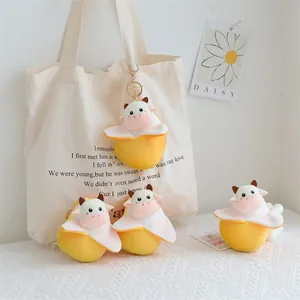 Primo piano di portachiavi a forma di mucca in peluche in gusci di frutta gialla
