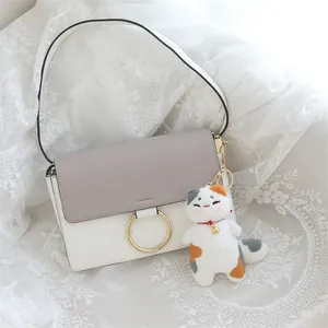Vista dettagliata di un simpatico portachiavi a forma di gatto calicò su una borsa