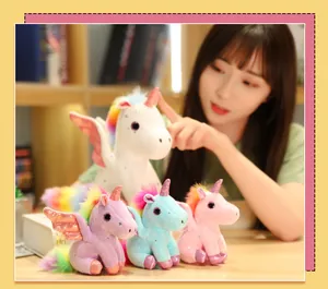Primo piano di peluche a forma di unicorno con ali glitterate in bianco, rosa, blu e viola