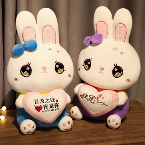 Close-up of white plush rabbits holding pink hearts with romantic Chinese embroidery and bows