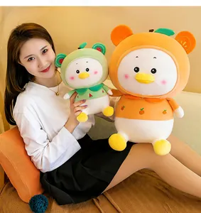 Close-up of cute fruit-themed duck plush toys held by a model showing soft texture