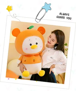 Detailed view of a young woman holding a large cute orange fruit duck plush toy indoors