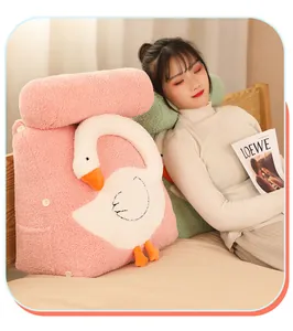 Detail of pink cartoon goose triangular backrest pillow on bed with model