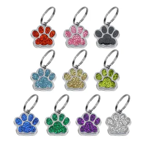 Detailed view of colorful glitter dog paw shaped pet ID tags with metal split rings