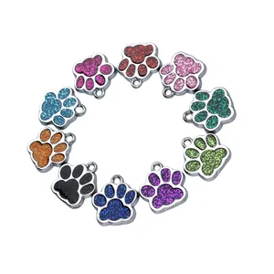 Detailed view of ten colorful glitter-filled paw print pendants for DIY pet tags set