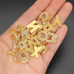 Detail view of 15mm gold alloy alphabet charms with rhinestones for DIY jewelry