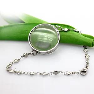 Detailed view of stainless steel heart link bracelet with round curved glass locket