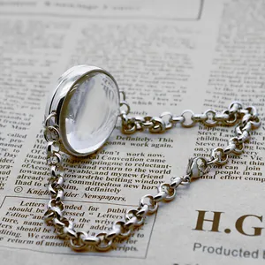 Close-up of stainless steel floating locket bracelet on vintage newspaper background