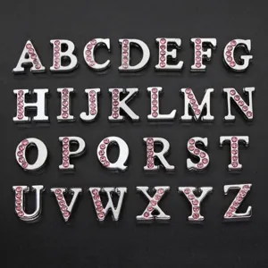 Close-up of 8mm silver metal alphabet charms with pink rhinestones for DIY bracelets.