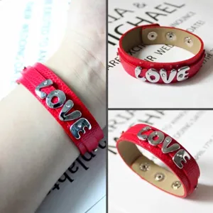 Detailansicht eines roten Lederarmbands mit funkelnden silbernen LOVE-Buchstabenanhängern