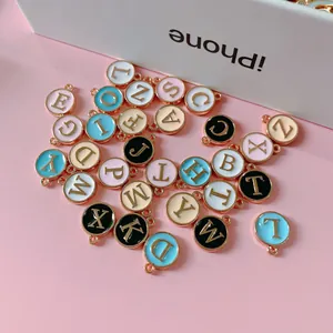 Vista detallada de colgantes de letras en esmalte de colores con bordes de metal oro rosa