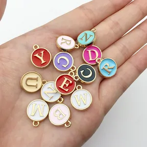 Vista detallada de varios dijes de letras iniciales de esmalte redondos para joyería artesanal