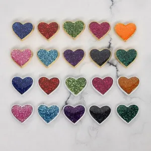Close-up macro view of 8mm glitter heart beads with colorful drip oil finish for DIY jewelry