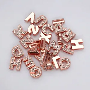Detailed macro view of 8mm rose gold alloy alphabet slide beads with sparkling rhinestones
