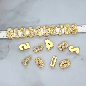Detailed macro view of gold rhinestone number charms for personalized DIY bracelets