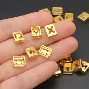 Macro shot of 8mm golden hollow English letter beads for DIY jewelry bracelets and crafts.